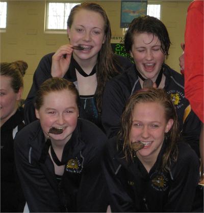 Lauren Higgenbotham -10, Joan Dregalla - 12, Katie Ashmun - 12 and Bridget Liddy - 12,  accept their bronze medal at the SWC championships after placing 3rd in the 400 Freestyle Relay